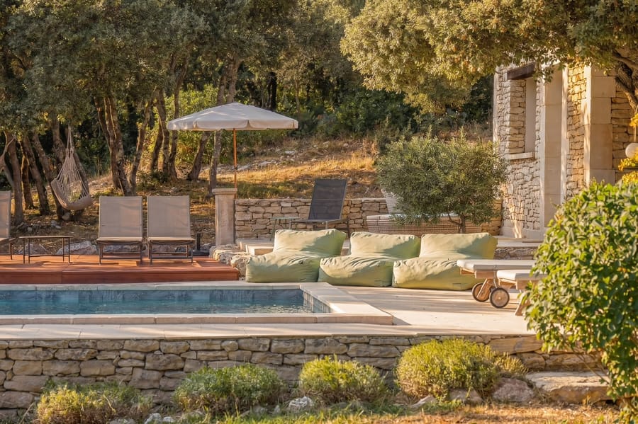 La piscine, ses transats et ses poufs